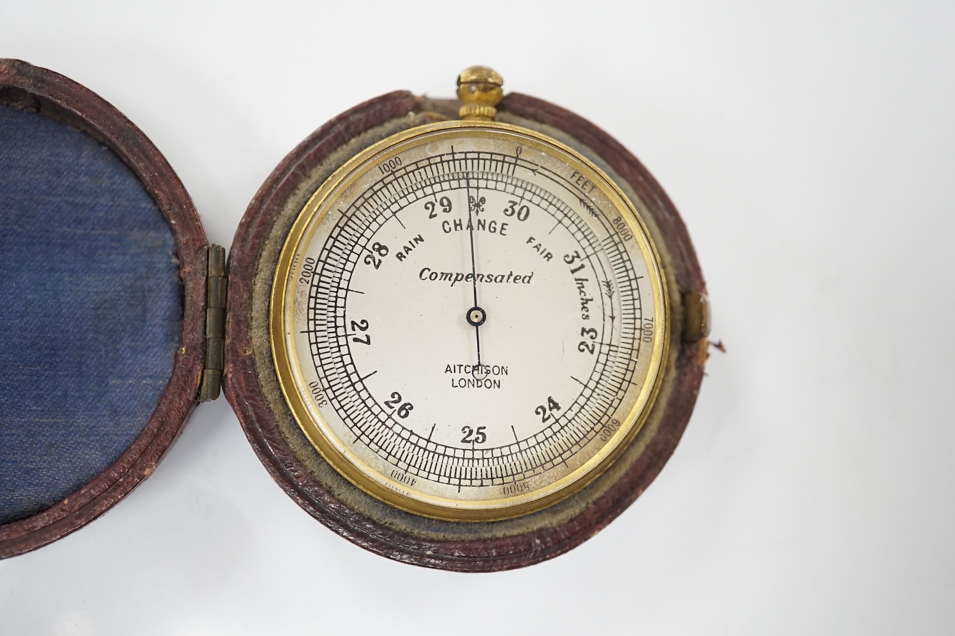 An Aitchison pocket barometer housed in original leather case, overall 6cm in diameter. Condition - fair